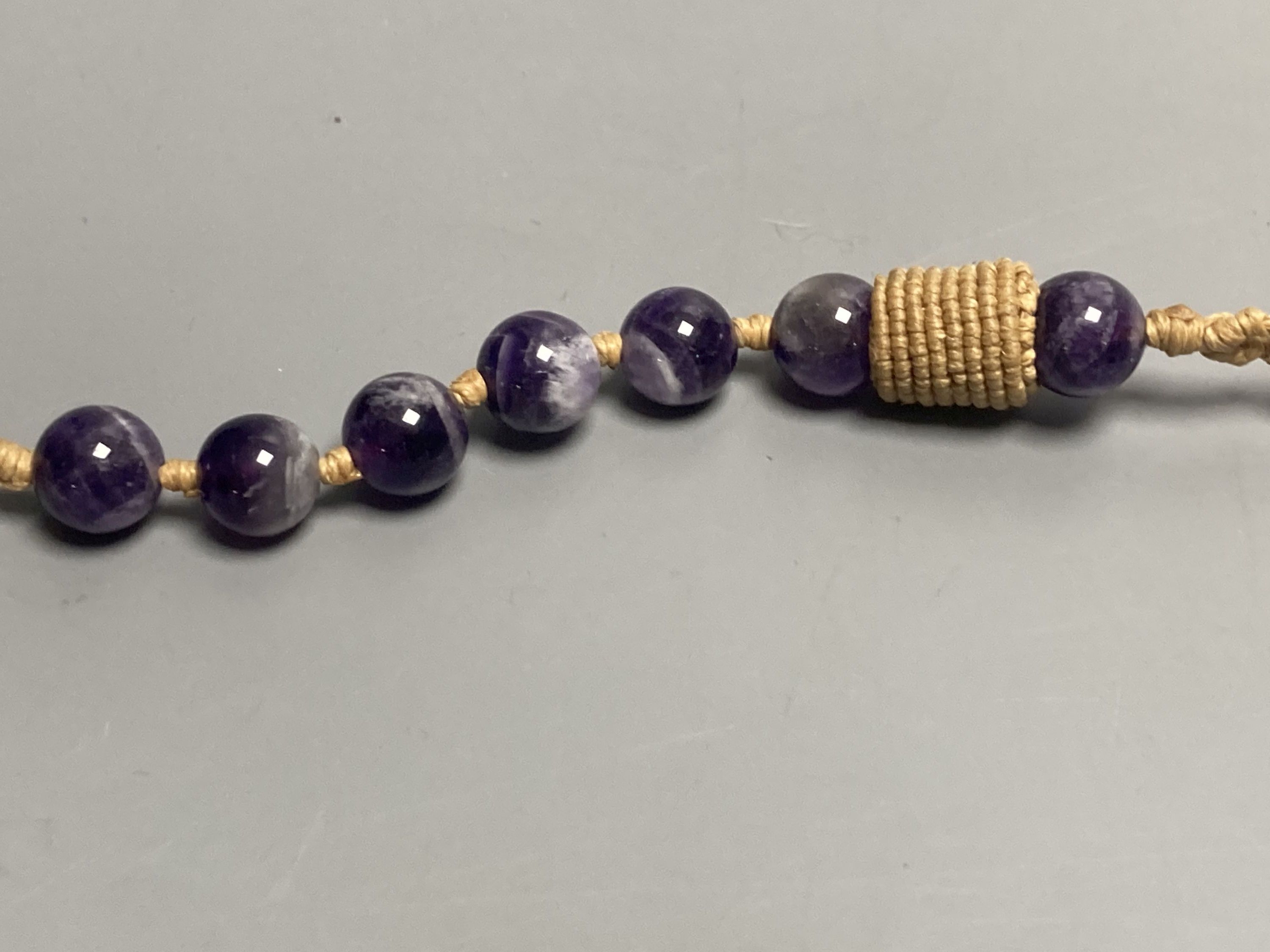 An amethyst bead necklace with amethyst pebble pendant.